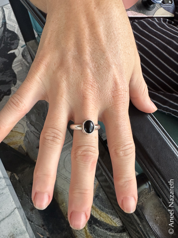 A ring with a simple silver band and an oval onyx stone mounted on it
